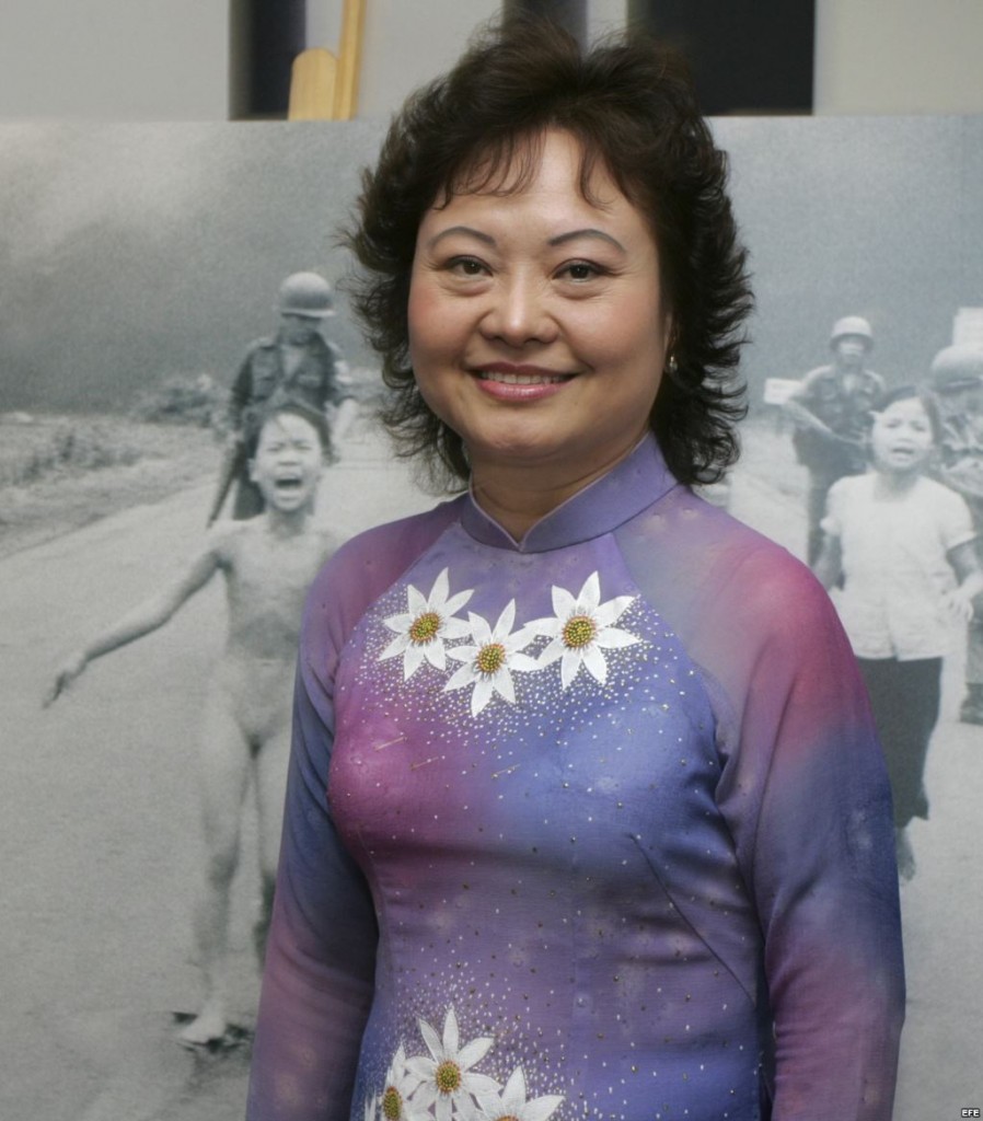 Kim Phuc junto a la fotografía de la niña del napalm
