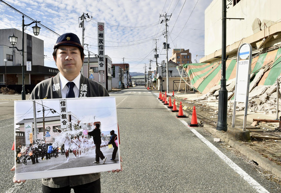 Un vecino de Namie muestra la foto de un día festivo en su ciudad antes de quedar desierta por el accidente nuclear- EFE