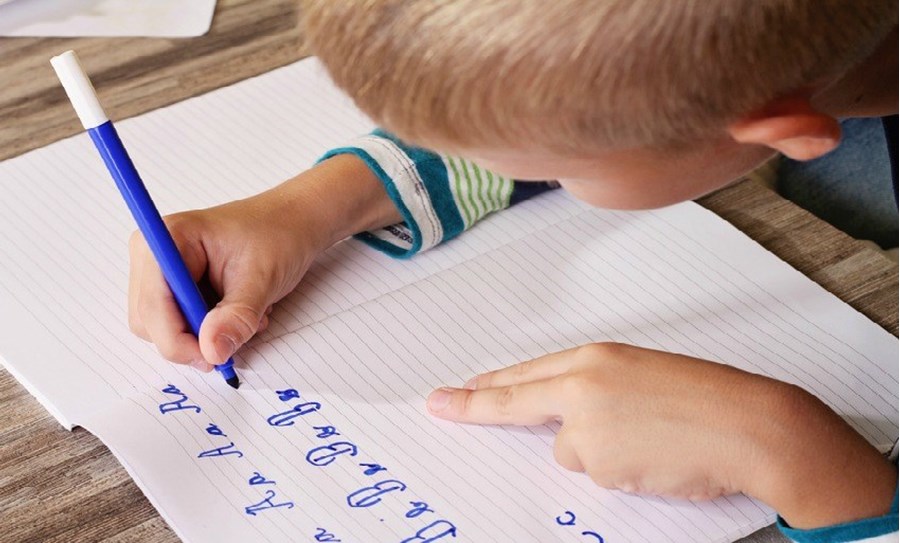 Niño escribiendo a mano- Fotolia