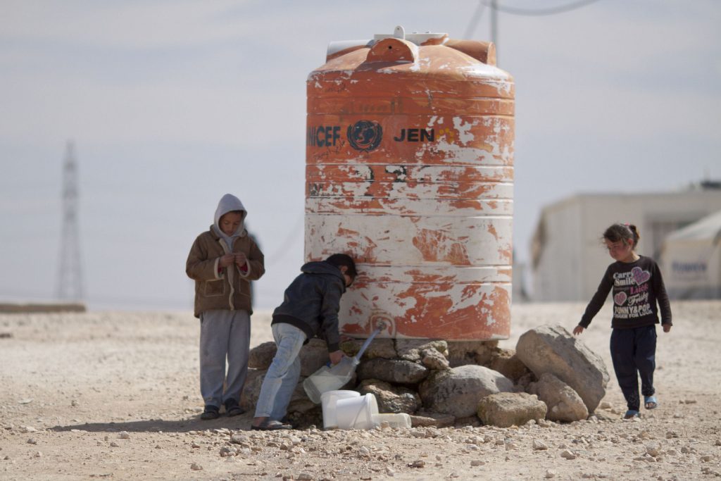 Niños llenando garrafas de agua en el campamento de Al-Zaatari, Jordania / Mustafa Bader
