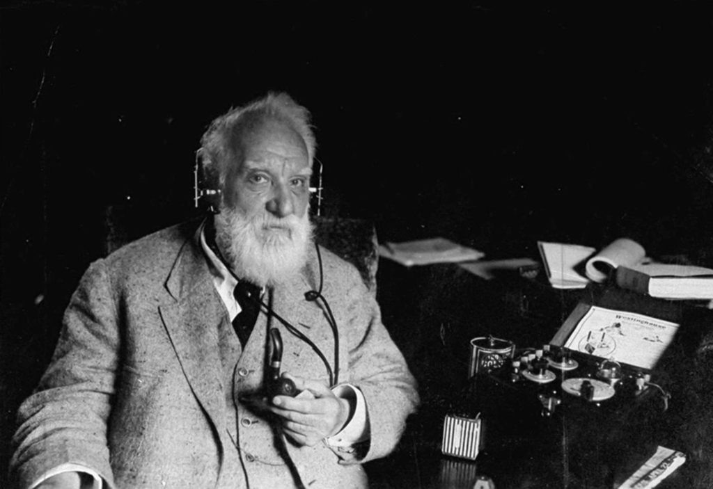Alexander Graham Bell con los audífonos del teléfono