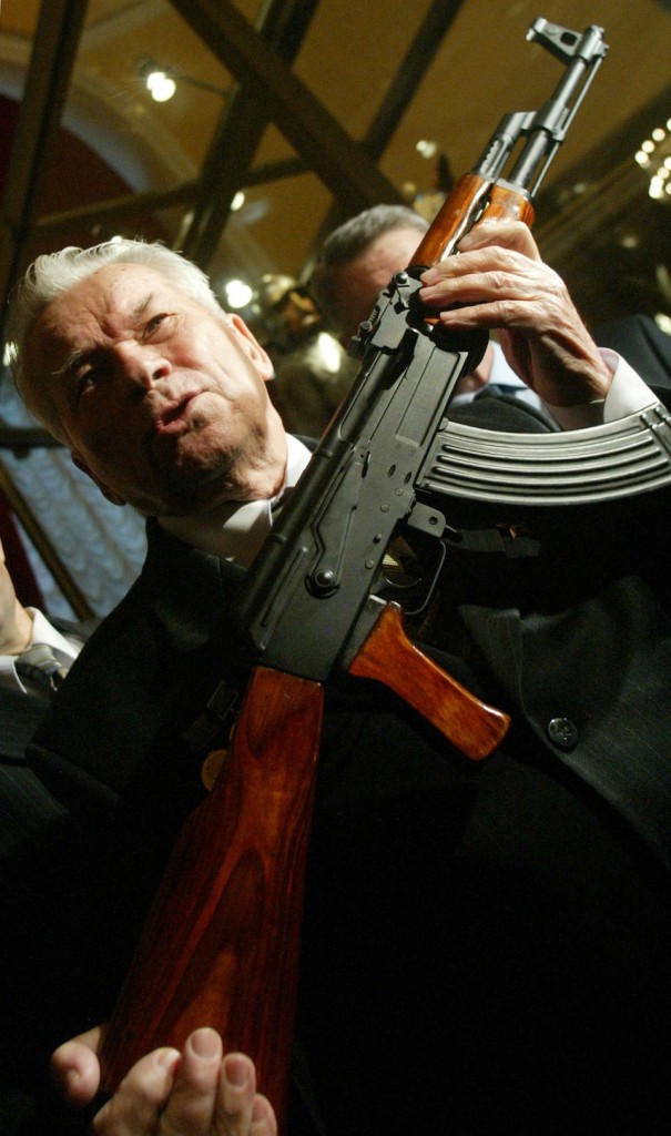 Mijail Kal·shnikov, sosteniendo un AK-47