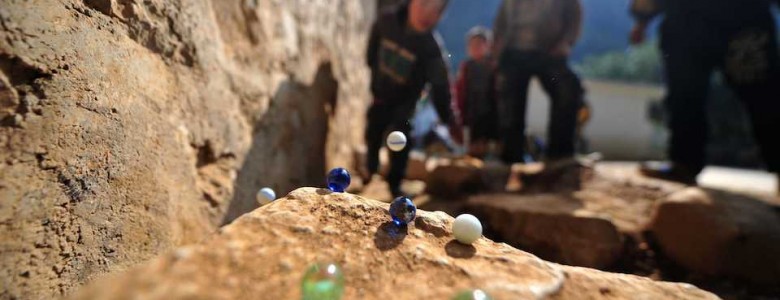 Niños, jugando canicas- Xinhua/Huang Xiaobang (archivo)