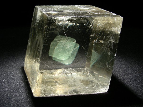 El espato de Islandia es una variedad de calcita, un mineral muy transparente con el cual se puede observar a simple vista el fenómeno de la doble refracción o birrefringencia