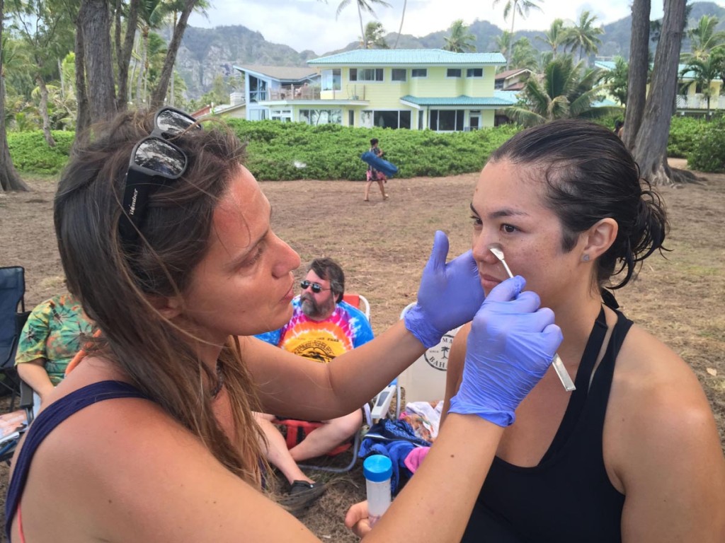 Íria Fernández tomando muestras de ácaros a una voluntaria en una playa de Hawai- Richard Coleman