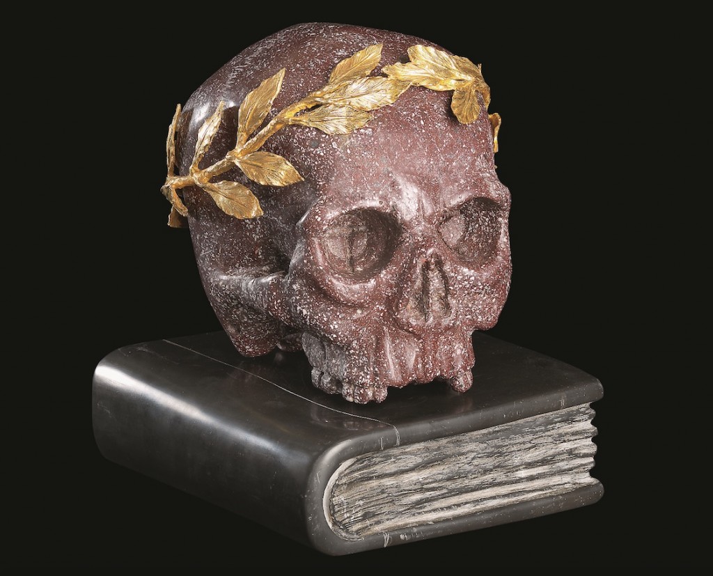 Cráneo en pórfido egipcio rojo, con la corona de laurel en bronce dorado y el libro en mármol negro de Bélgica