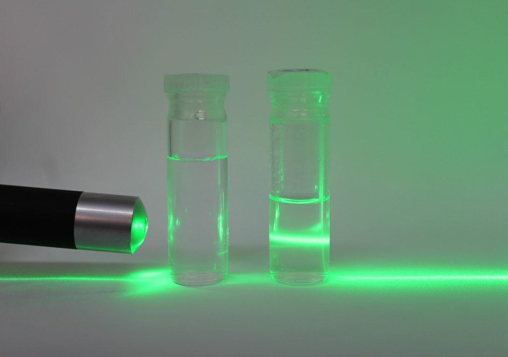 Visualización de un haz láser (verde) a través de agua pura (izquierda) y de nanocristales de celulosa dispersos en agua (derecha)