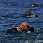 Refugiado sirio nadando con bebe en brazos para llegar a las costas de la isla griega de Lesbos, septiembre 2 de 2015- REUTERS/Alkis Konstantinidis