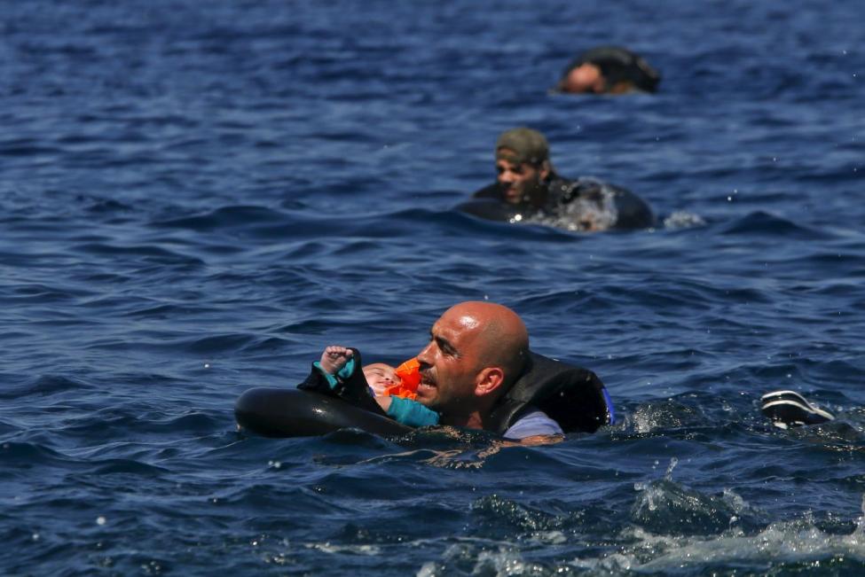 Refugiado sirio nadando con bebe en brazos para llegar a las costas de la isla griega de Lesbos, septiembre 2 de 2015- REUTERS/Alkis Konstantinidis