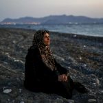 Una refugiada palestina ciega sentada en la playa al llegar a la isla griega de Kos, 12 de agosto de 2015- REUTERS / Yannis Behrakis