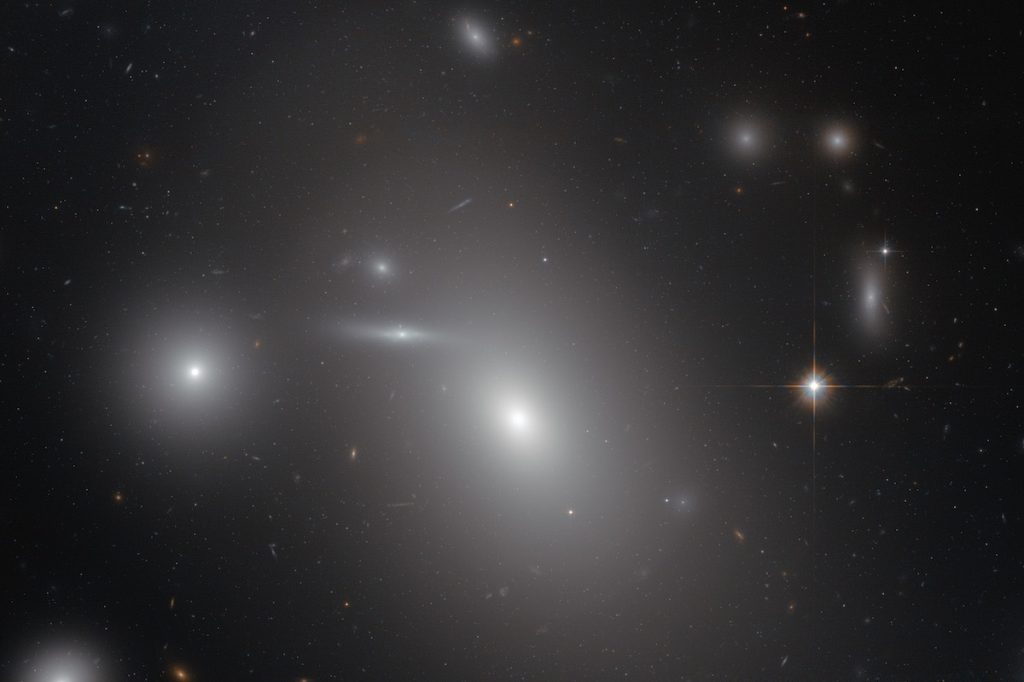 La galaxia elíptica NGC 4889, el objeto más brillante en el centro de la imagen, alberga al mayor agujero negro conocido- NASA, ESA