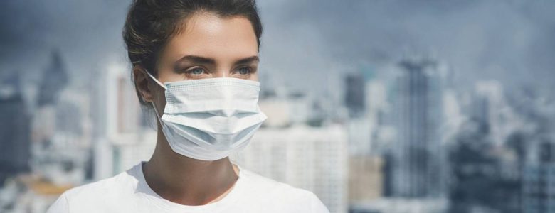 Vivir en zonas contaminadas puede hacer más vulnerables a las personas a padecer Covid-19 Mujer con cubrebocas y contaminación ambiental- Adobe Stock